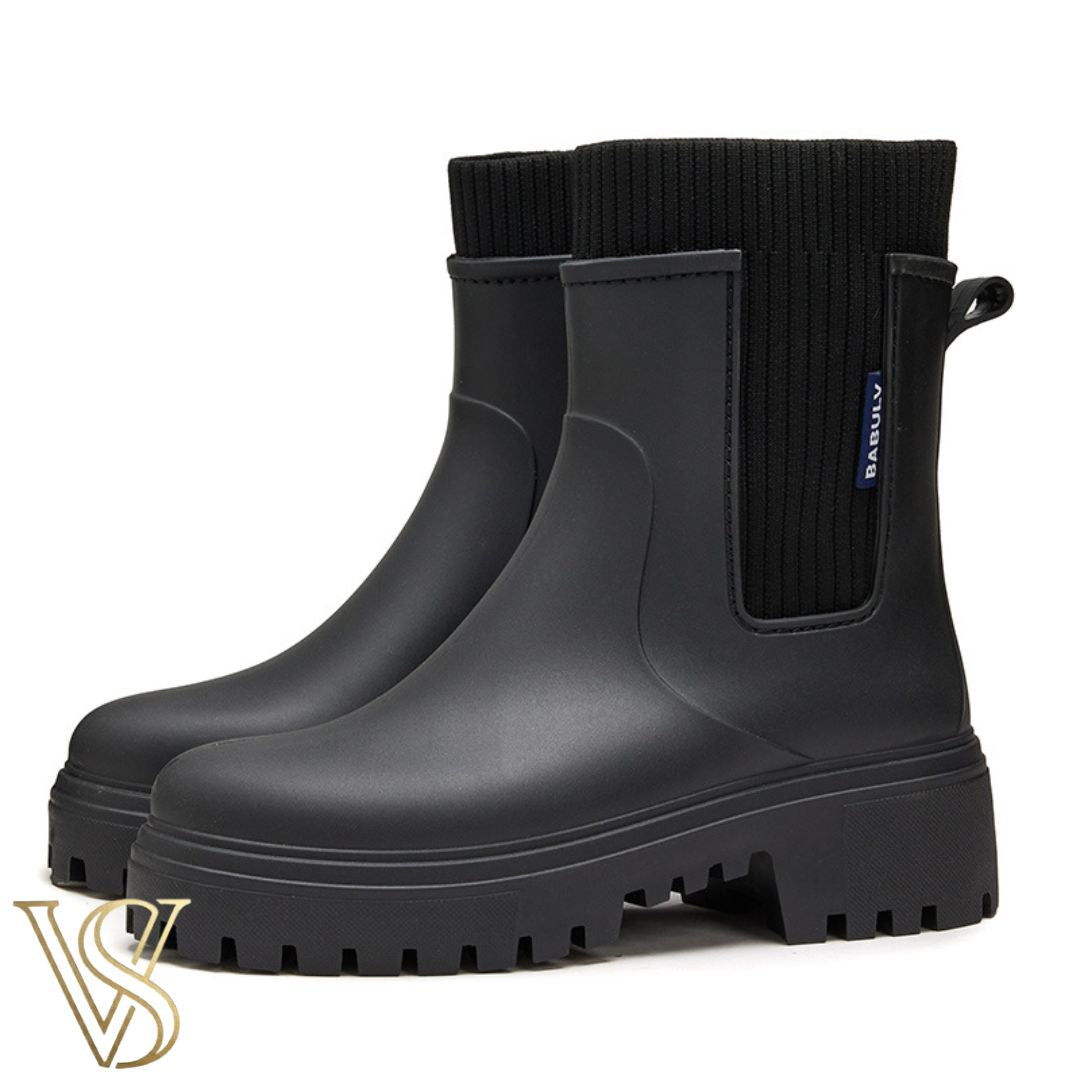 Black waterproof ankle boot with a chunky lug sole and matching black ribbed knit sock-style collar.