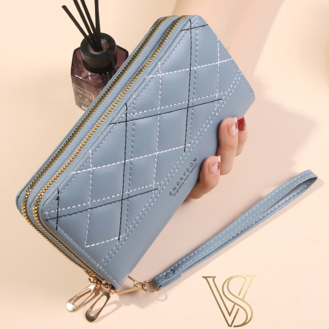 Slate blue quilted long wallet featuring contrast diamond stitching and double top zipper.