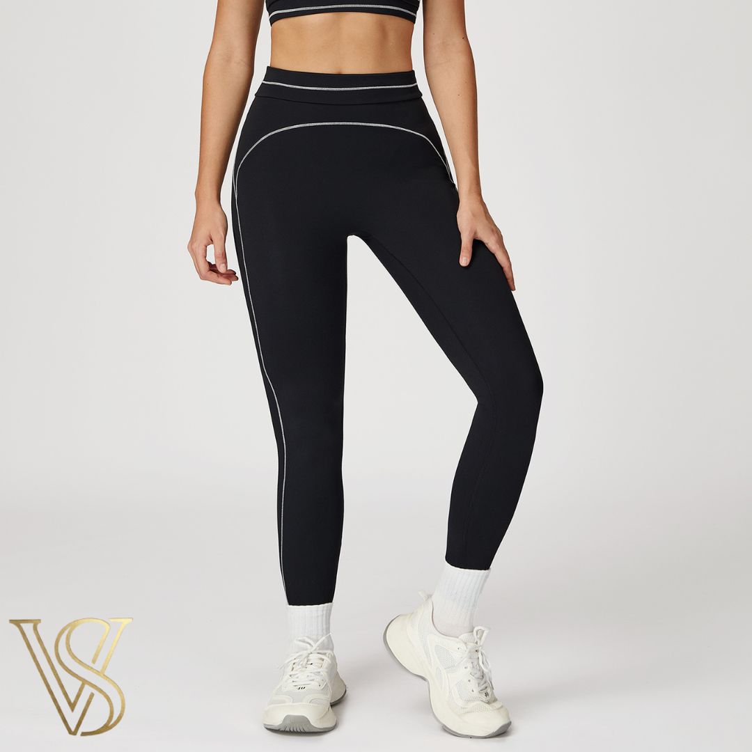 Black high-waisted seamless leggings featuring white contrast stitching in a curved pattern and a double-banded waist, branded by vstyles.