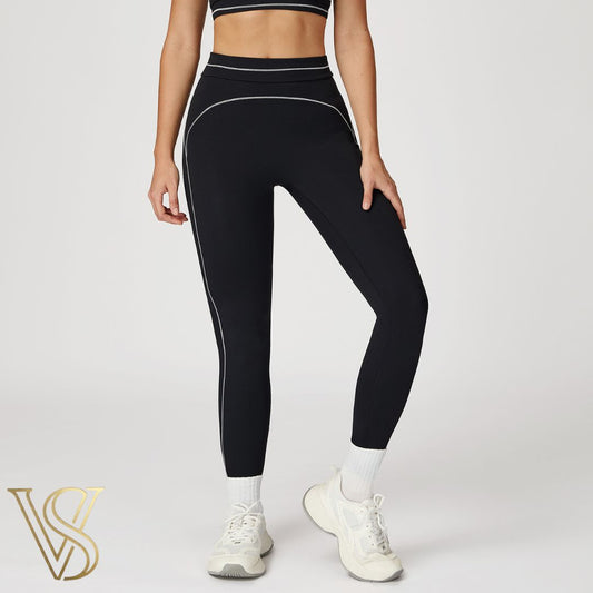 Black high-waisted seamless leggings featuring white contrast stitching in a curved pattern and a double-banded waist, branded by vstyles.