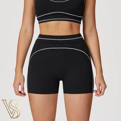 Black high-waisted athletic shorts featuring decorative white contrast stitching in a curved pattern, branded by vstyles.
