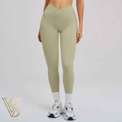 High-waisted sage green crossover leggings with a V-shaped waistband and a smooth, full-length silhouette for vstyles.