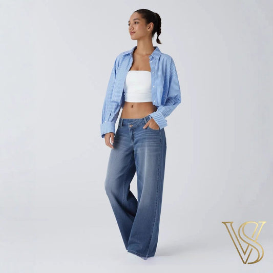 Trendy medium blue wide-leg jeans featuring a low-rise fit, styled with a white tube top and a blue striped button-down for a contemporary vstyles look.