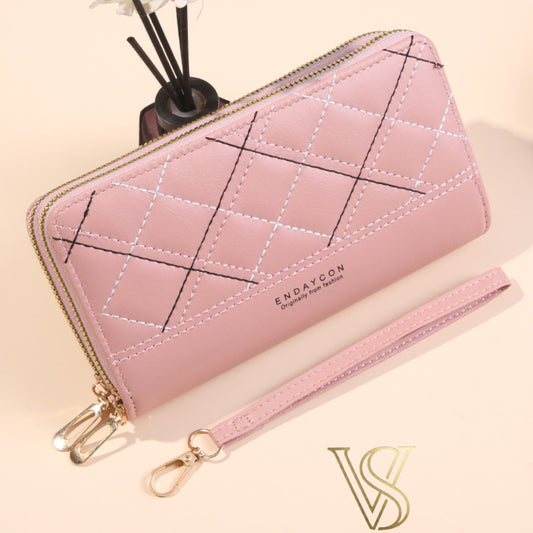 Blush pink long wallet with diamond-patterned contrast stitching, double zipper, and wristlet strap.