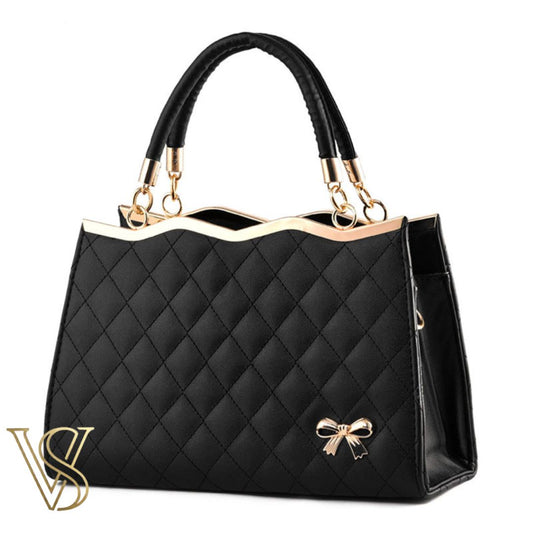 Elegant black quilted handbag with a wavy gold-trimmed top, double handles, and a small gold bow charm.
