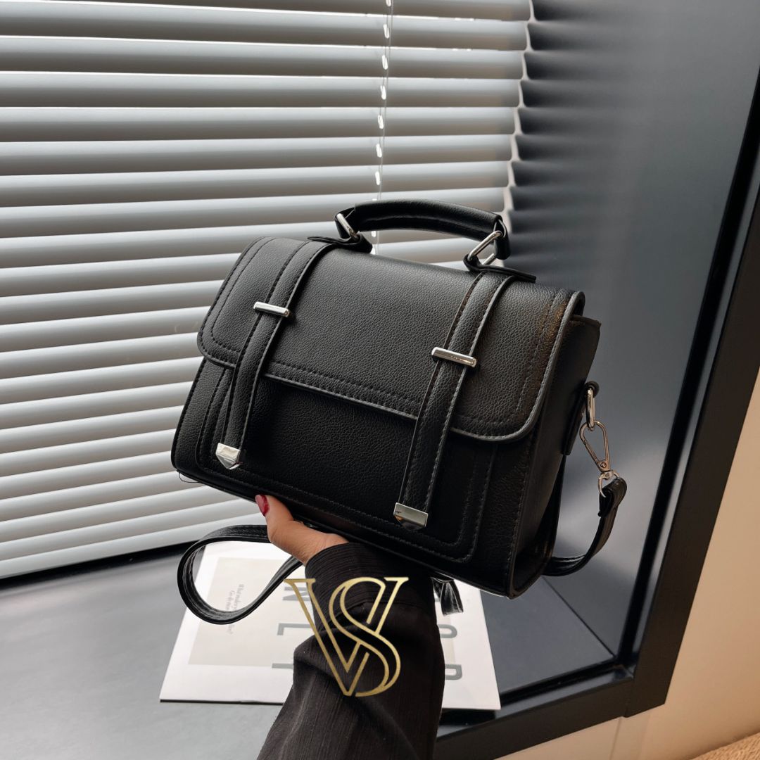 Elegant black structured satchel with silver hardware, a top handle, and a detachable shoulder strap.