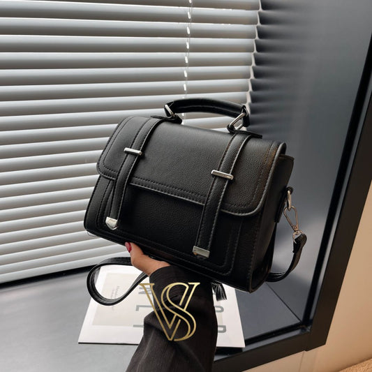 Elegant black structured satchel with silver hardware, a top handle, and a detachable shoulder strap.