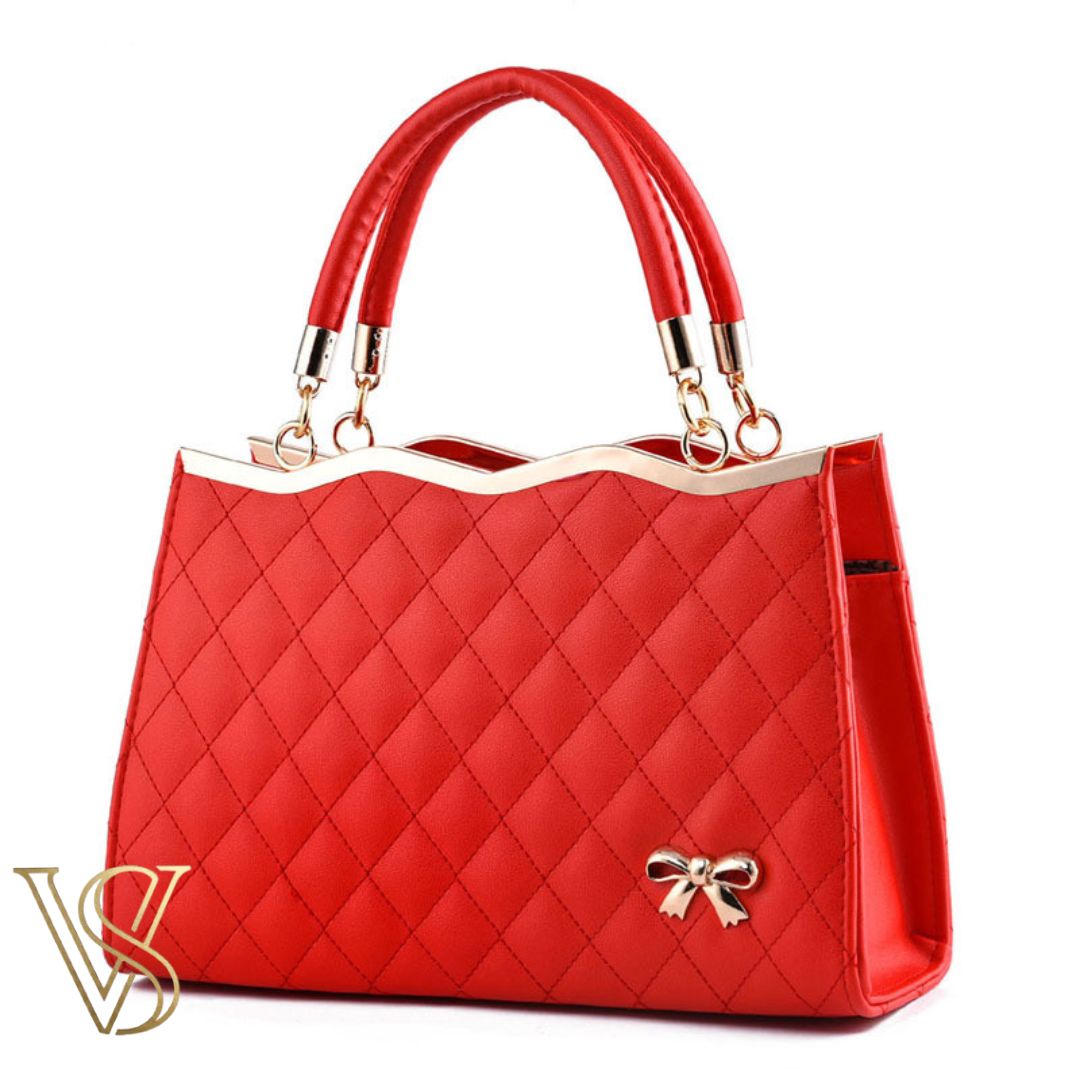 Vibrant bright red quilted handbag featuring a wavy gold-rimmed top, sturdy top handles, and a decorative gold bow.