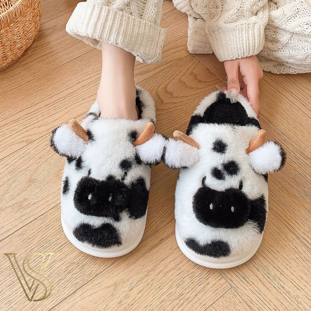 Classic black and white cow-themed plush slippers with a fluffy texture and whimsical design, perfect for cozy days at home from vstyles.