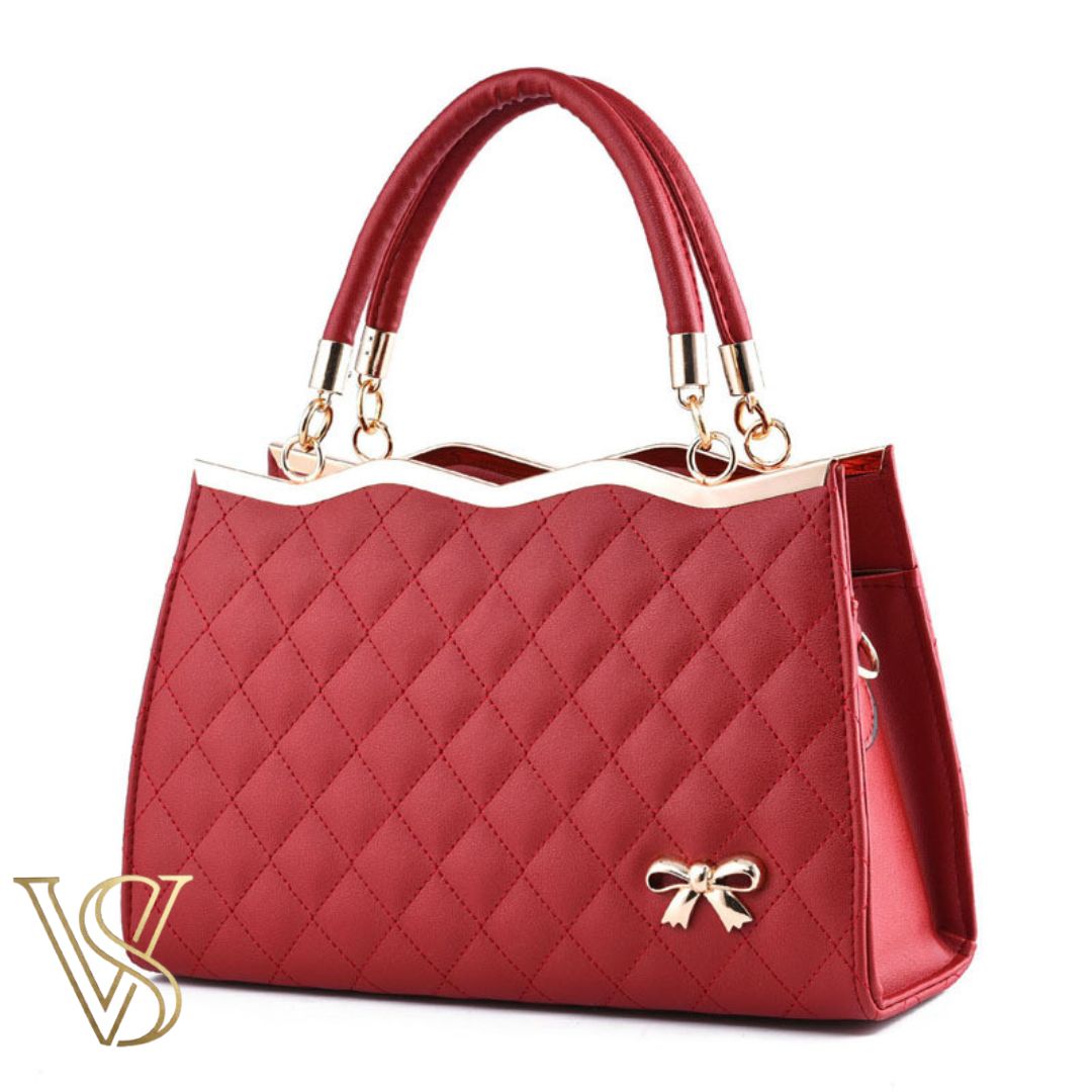 Sophisticated dark red quilted handbag with a scalloped gold top edge, dual handles, and a gold bow detail.