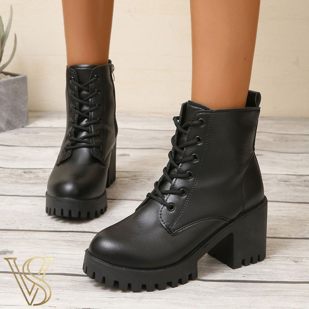 Black lace-up combat boots with a high chunky block heel, rugged lug sole, and functional side zipper.