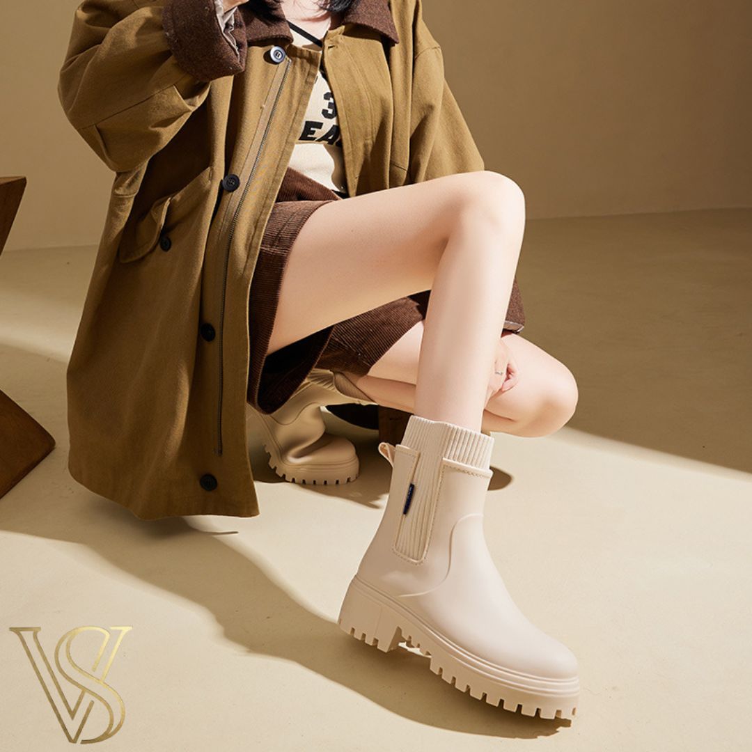 Off-white waterproof ankle boot with a chunky lug sole and matching cream ribbed knit sock-style collar.