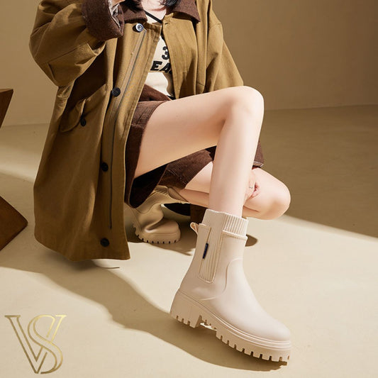 Off-white waterproof ankle boot with a chunky lug sole and matching cream ribbed knit sock-style collar.