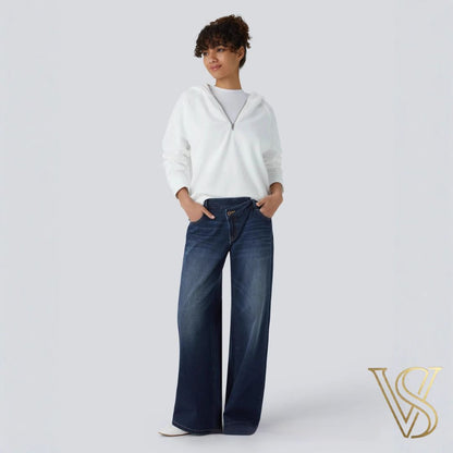 Deep indigo wide-leg jeans featuring a low-rise waistband, effortlessly styled with a white quarter-zip hoodie for the vstyles collection.