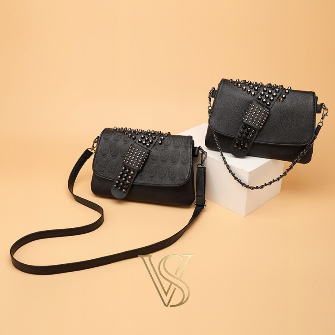 Black embossed skull crossbody bag with edgy silver studded detailing on the flap and adjustable shoulder strap.