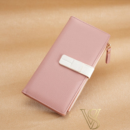 Soft pink textured leather long wallet with a clean white contrast strap and zipper detail.