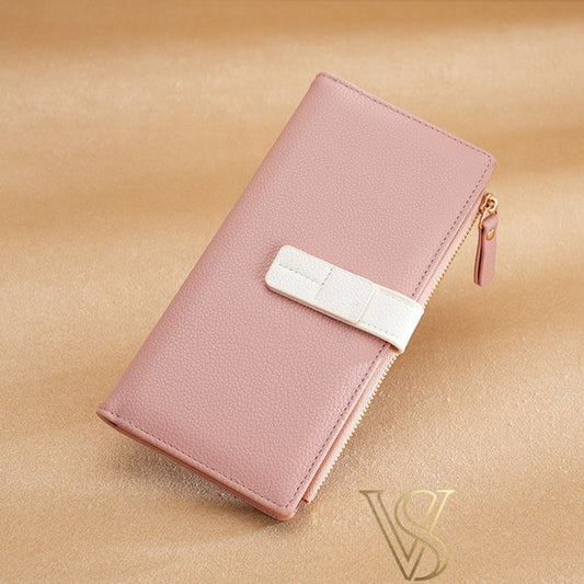 Soft pink textured leather long wallet with a clean white contrast strap and zipper detail.