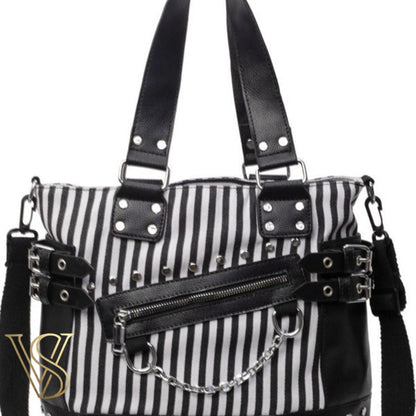 Punk-inspired tote bag with black and white vertical stripes, detailed with silver studs, side buckles, and a hanging metal chain.