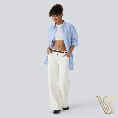 Elegant cream wide-leg trousers accented with a black belt, paired with a white crop top and an oversized light blue shirt for a sophisticated vstyles ensemble.