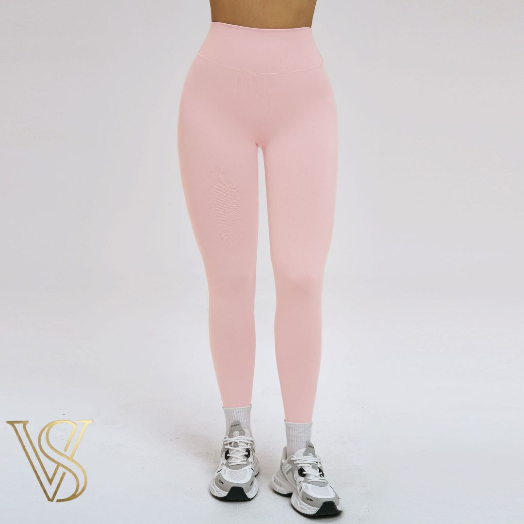 Soft light pink high-waisted leggings featuring a seamless texture and supportive waistband, perfect for yoga and fitness by vstyles.
