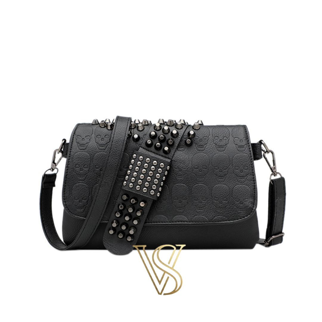 Black embossed skull crossbody bag with edgy silver studded detailing on the flap and adjustable shoulder strap.