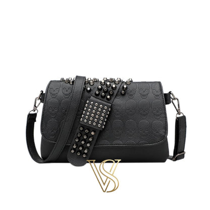 Black embossed skull crossbody bag with edgy silver studded detailing on the flap and adjustable shoulder strap.
