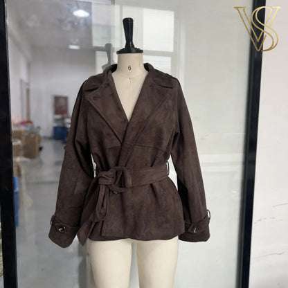 Sophisticated dark brown belted jacket with a suede-like texture, featuring a wide collar and button-front closure, styled with blue jeans for a chic vstyles look.