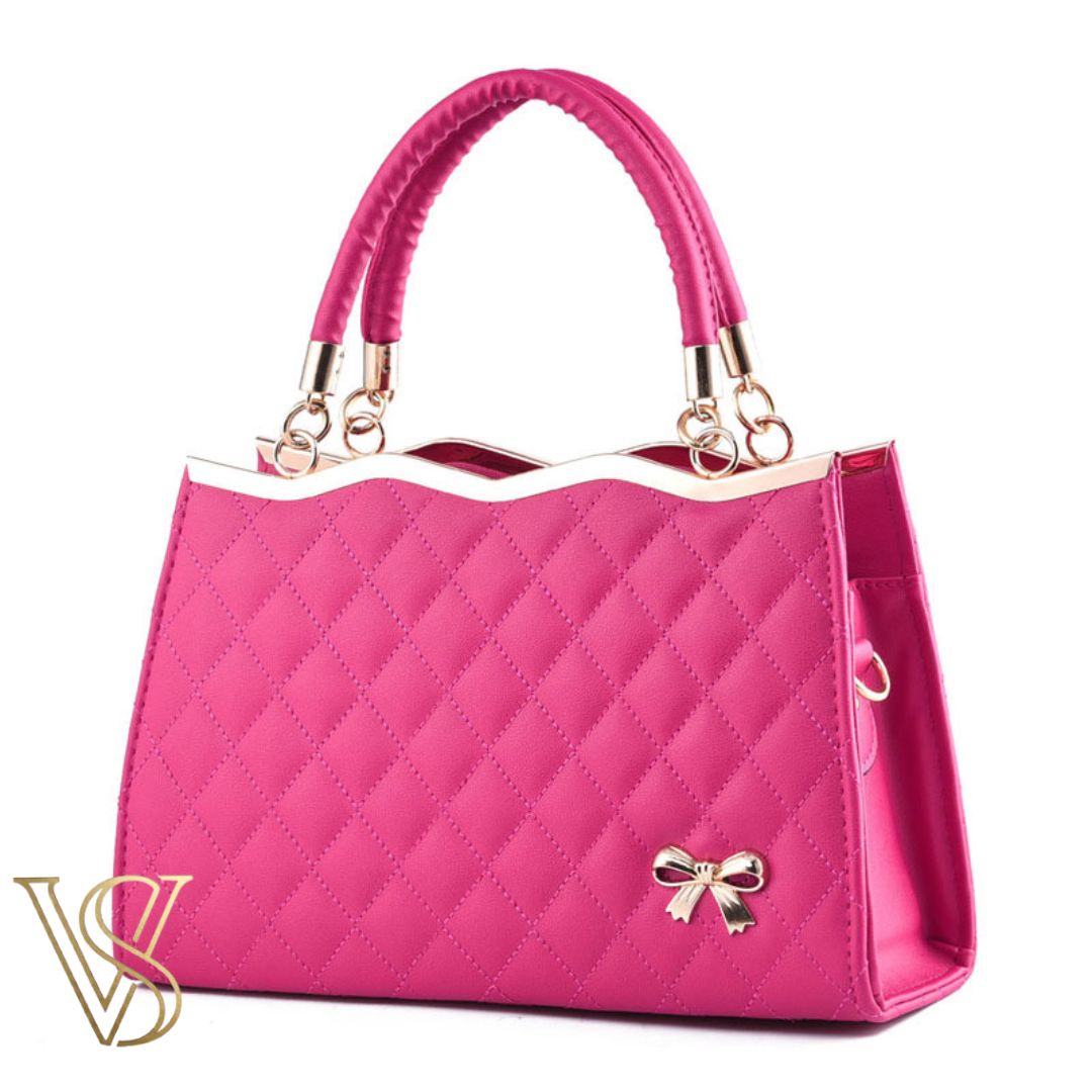 Bold hot pink quilted handbag with a wavy gold-edged top, double handles, and a gold bow accent.