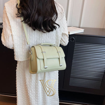 Trendy sage green crossbody satchel with a top handle and silver hardware accents.