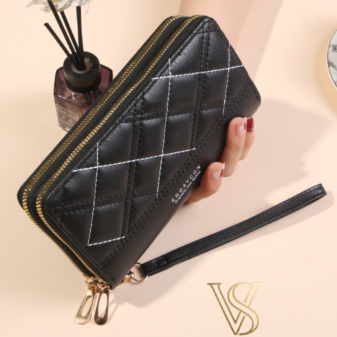 Black long wallet featuring contrast diamond-patterned stitching, double zipper closure, and wristlet.