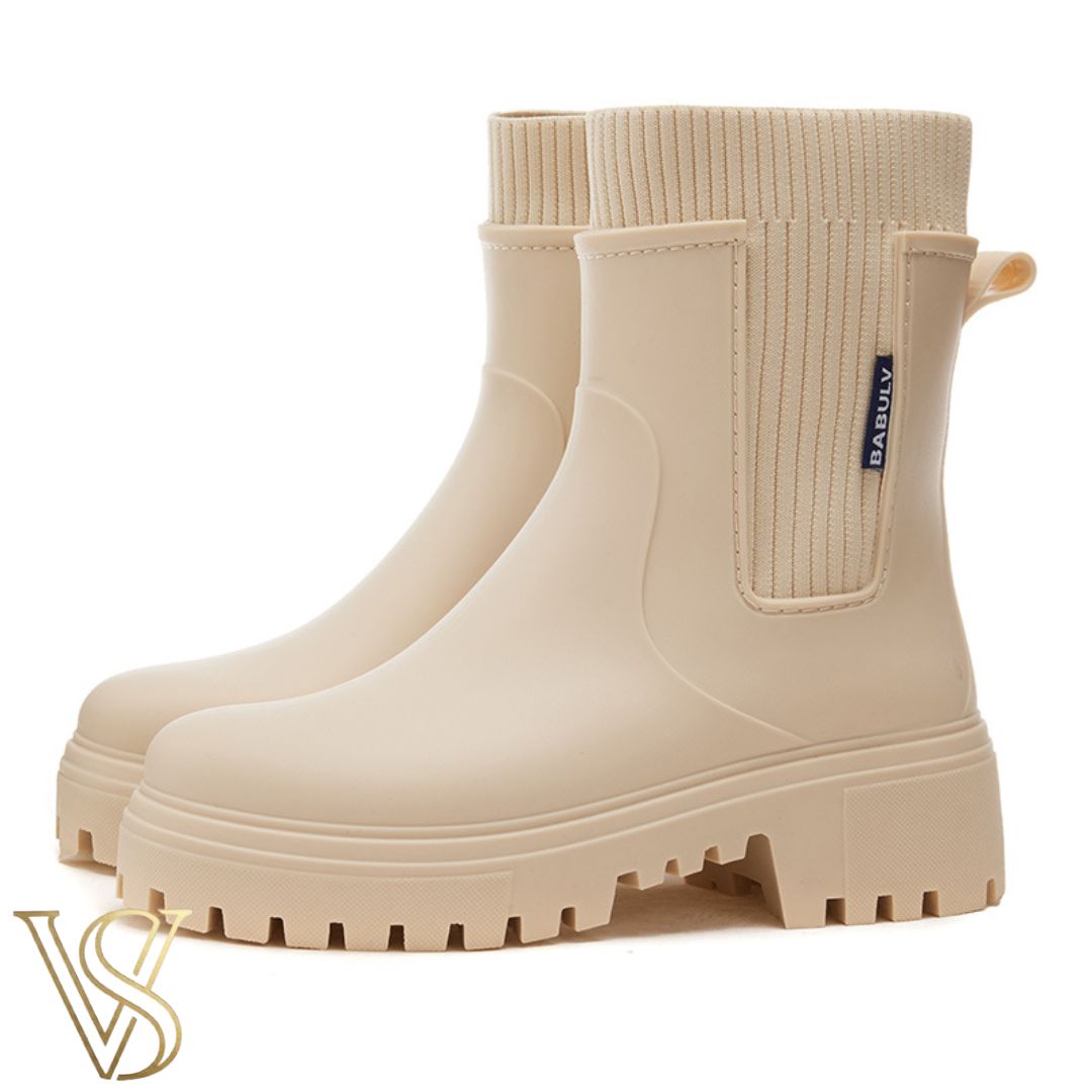 Off-white waterproof ankle boot with a chunky lug sole and matching cream ribbed knit sock-style collar.