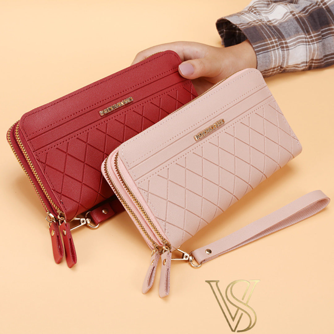 Pair of quilted long wallets in deep red and light pink, both featuring double zippers and wristlet straps.